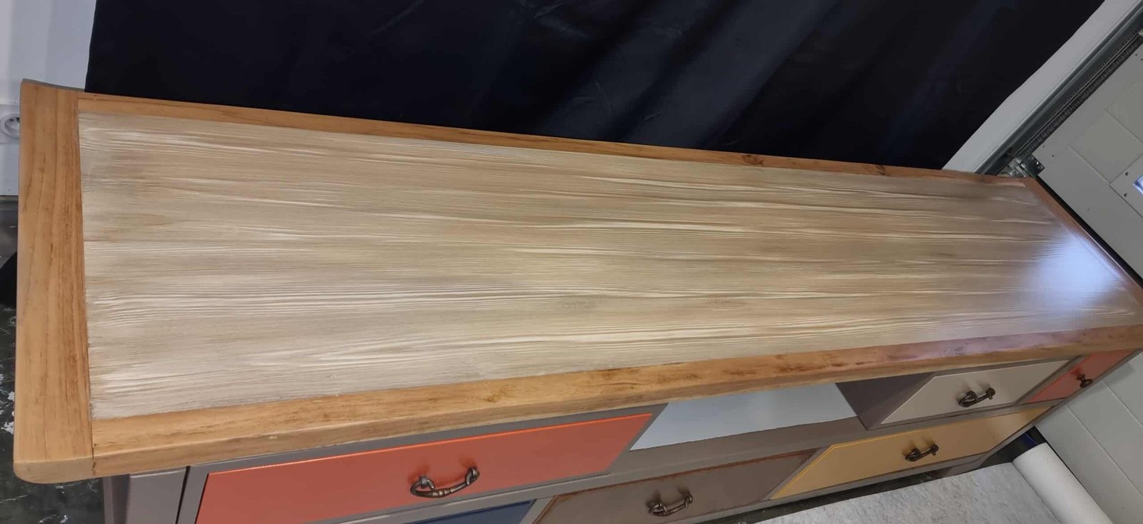 Détail des tiroirs peints bleu, jaune et orange du meuble TV exotique